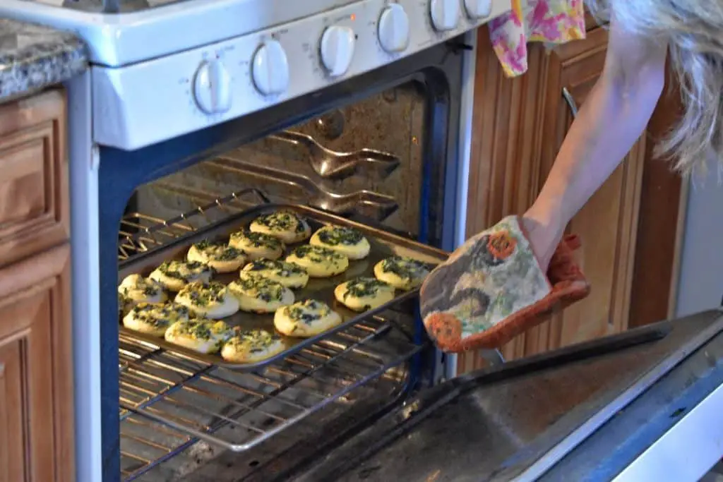 Someone putting a pan full of food to cook into the oven.